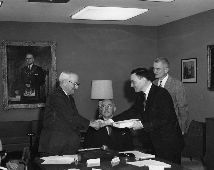 Richard Hewlett shakes former president Harry S. Truman’s hand, as he and co-author Oscar Anderson (standing) present him with the first volume of the Atomic Energy Commission history in 1962. Dean Acheson sits between them. Harry S. Truman Library 