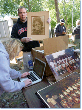 During the North Omaha History Harvest, University of Nebraska-Lincoln students inventoried and processed hundreds of artifacts from a storage container on the grounds of the Great Plains Black History Museum, which had been closed for more than a decade. Here, Matt Koziol and Jessica Hare work with a collection of photographs.