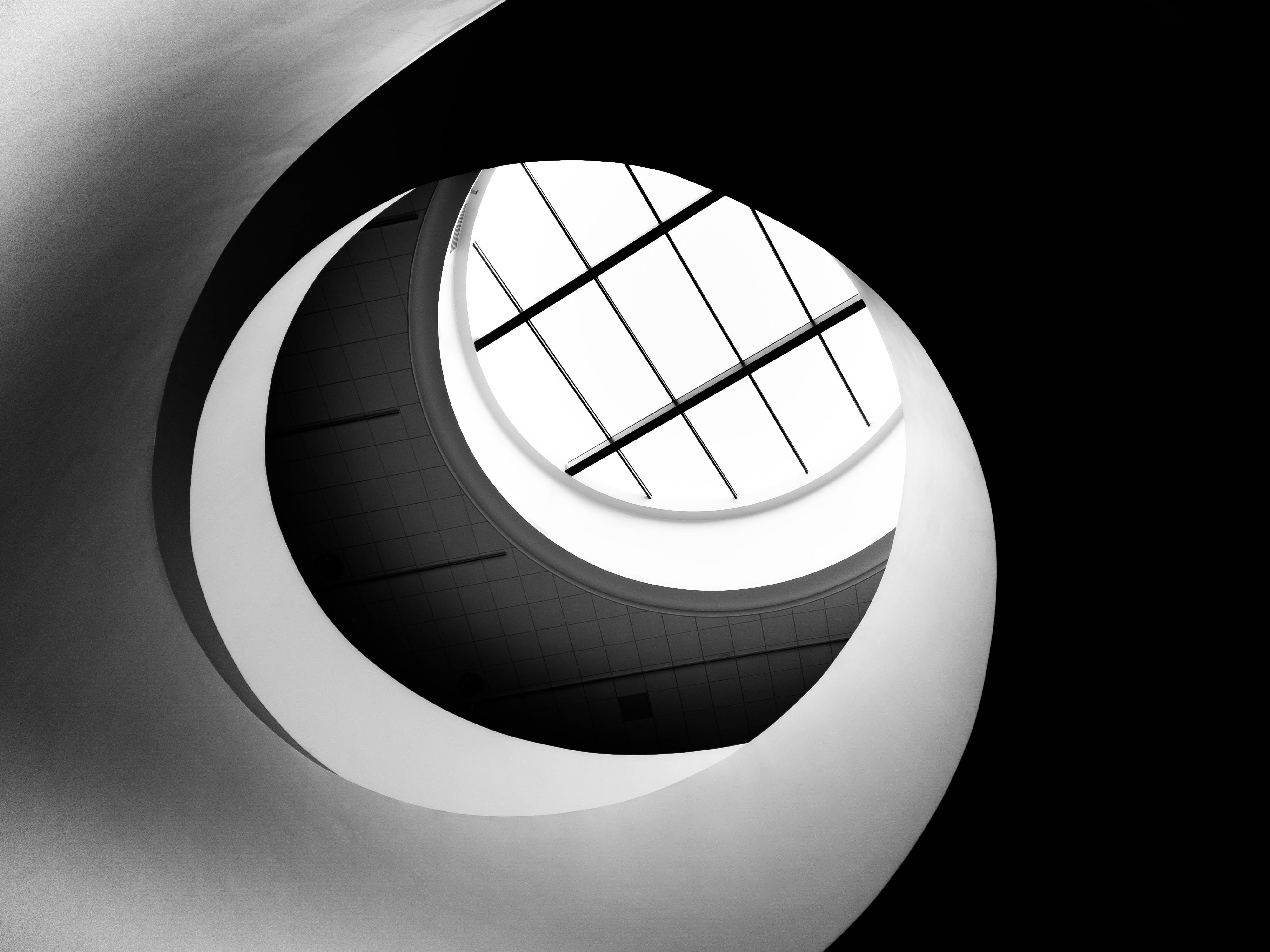 A round ceiling with a window in the center and two spirals surrounding the window opening. The right spiral is black and the left spiral is white.