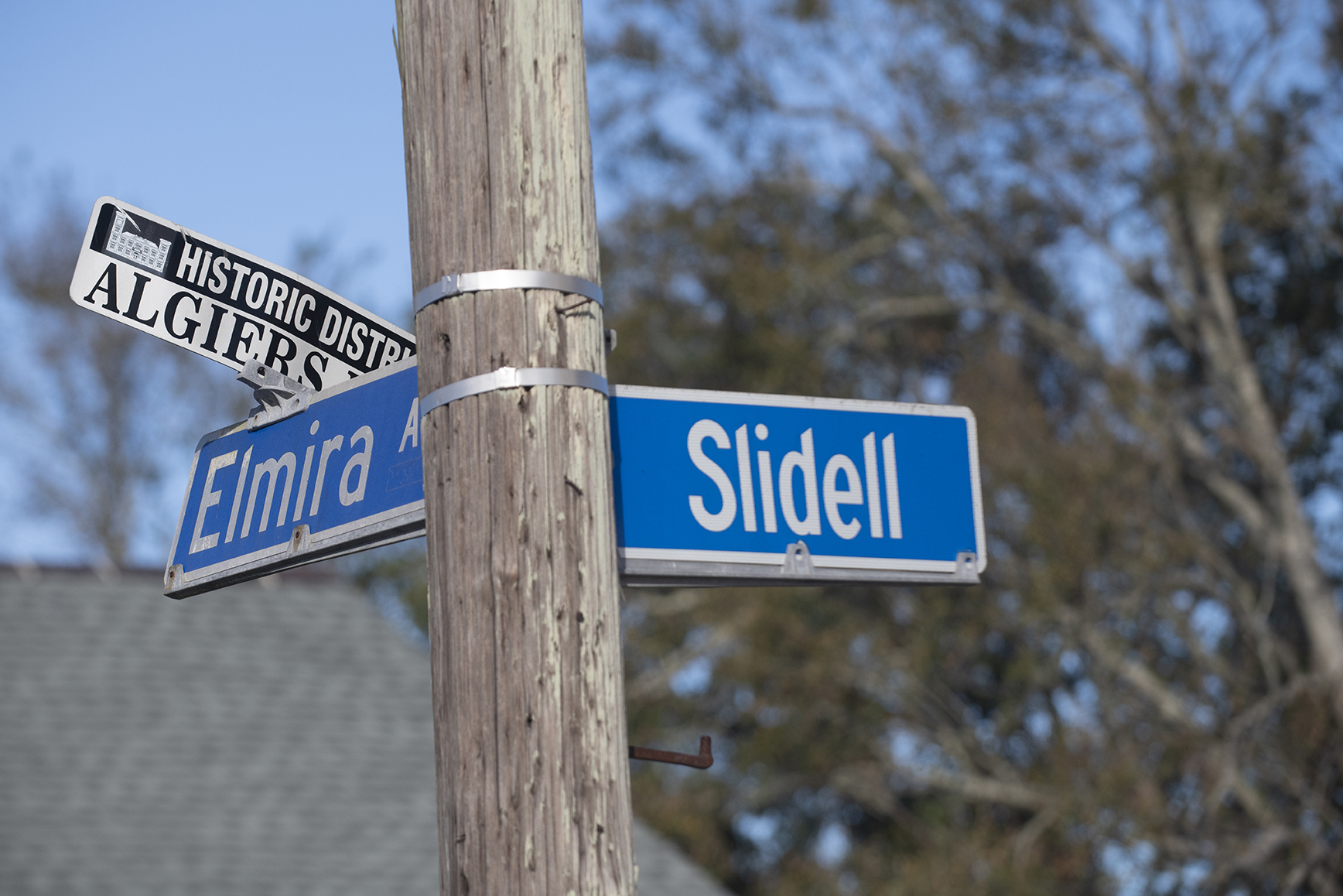 Blue street signs on a wooden poll in New Orleans. The street signs are at the crossroads of Slidell and Elmira, and the historic district of Algiers.