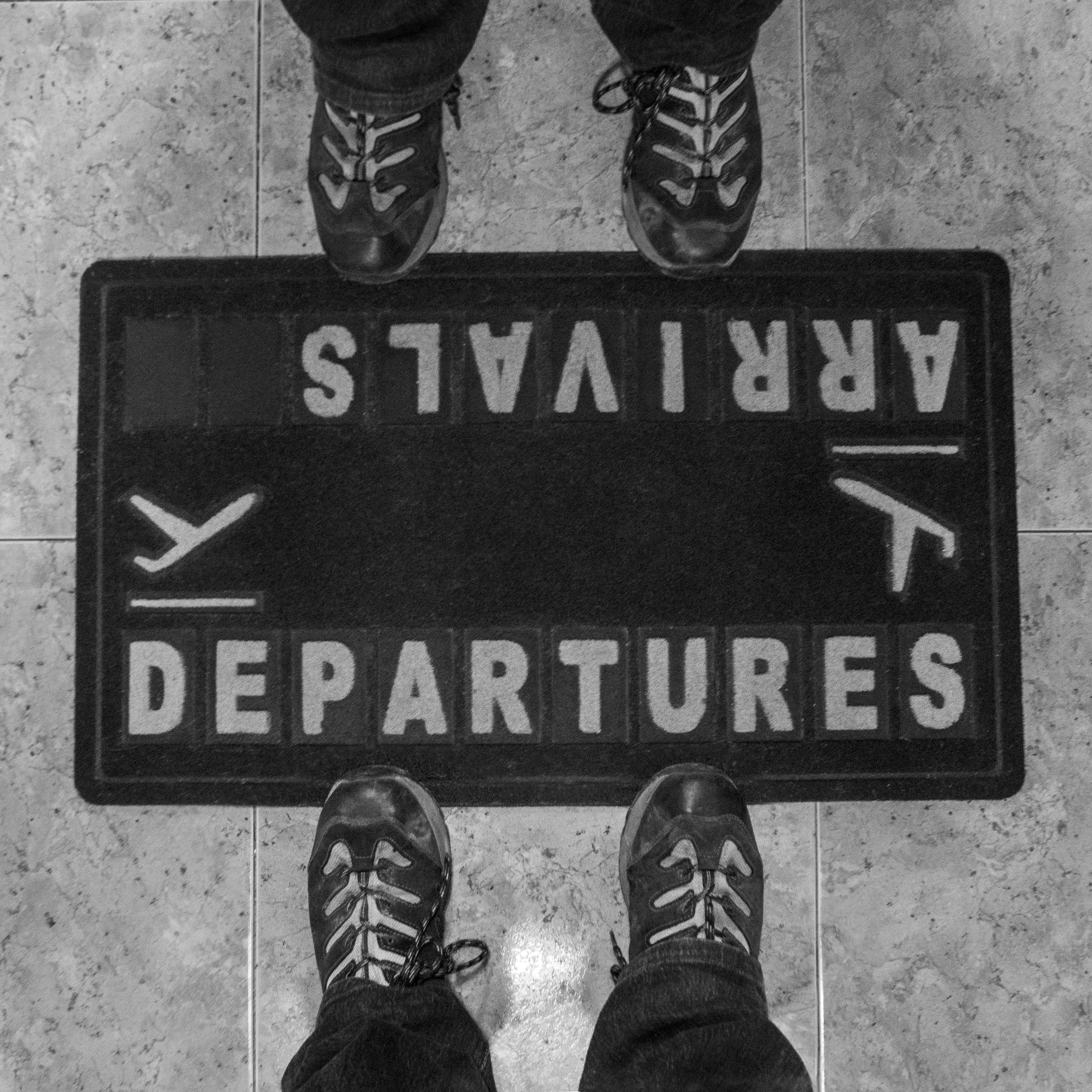 A welcome mat which says “arrivals” on one side and “departures” on the other