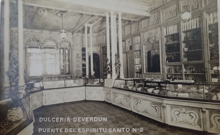 Black and white image of an ornate candy shop with the words 