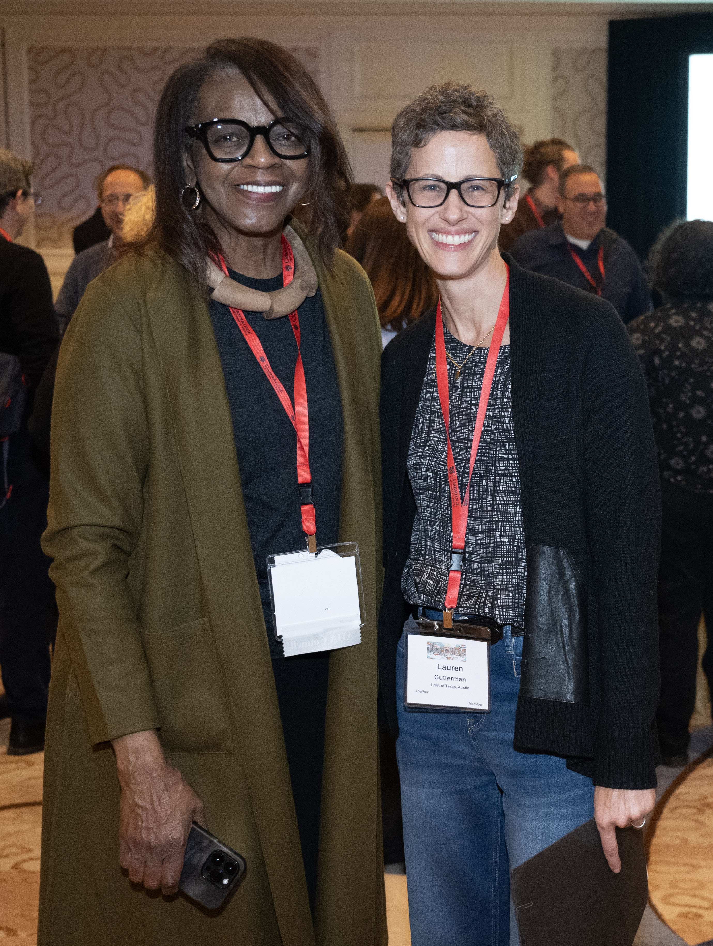  An older Black woman wearing glasses and a green sweater smiling next to a white woman with short gray-brown hair.