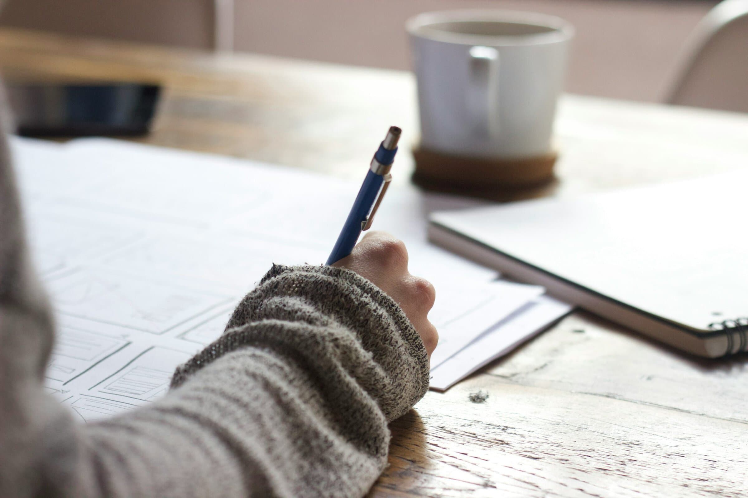 Hand writing at wooden table