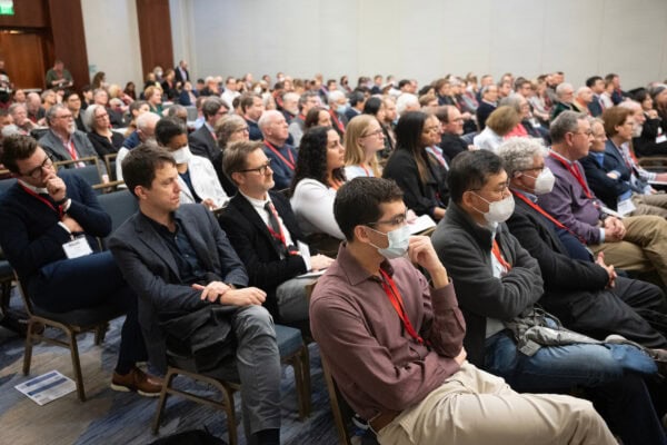 A wide shot of an audience staring at a presentation