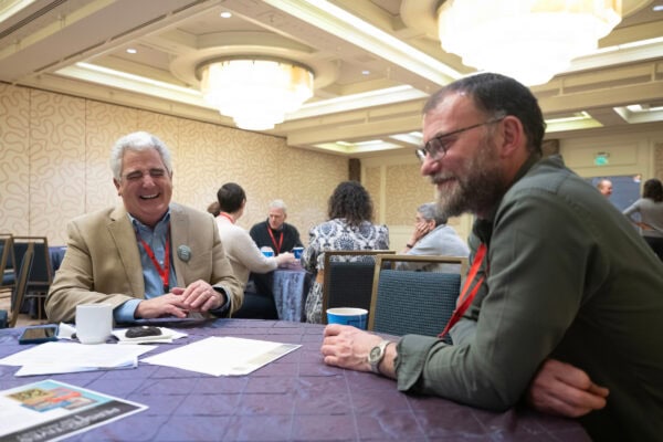 Two men sitting at a table laughing in conversation