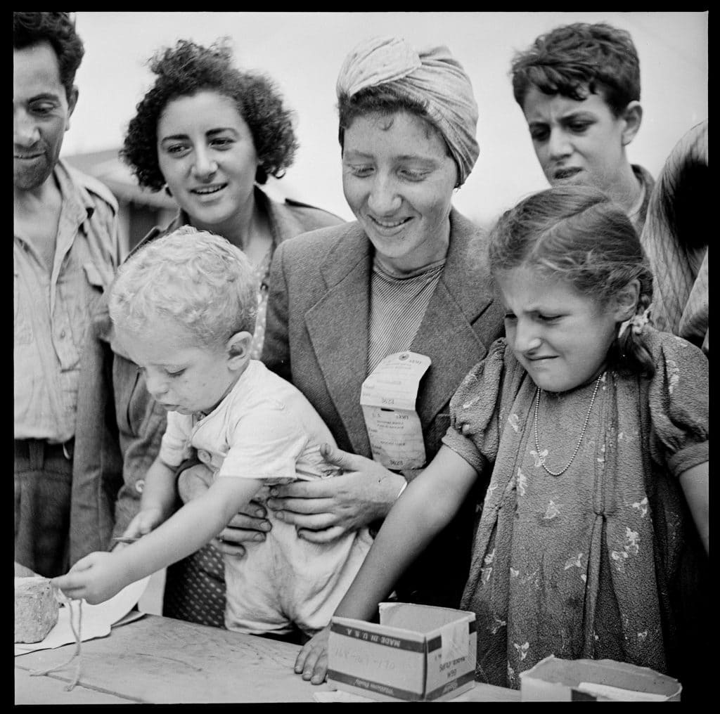 Black and white image of women and children dressed in 40s era clothing