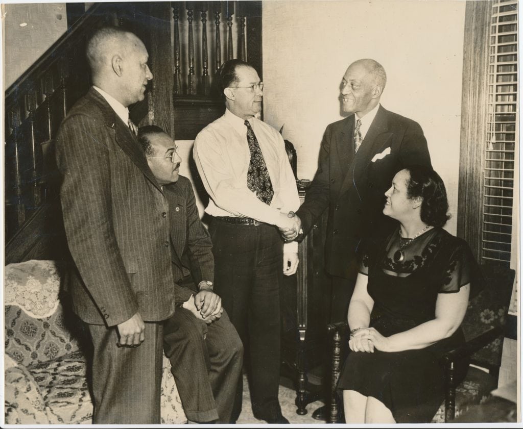 African American homeowners Orsell and Minnie McGhee (center and seated, respectively) turned to the NAACP when a group of white homeowners sought to oust them from their home on the basis of a racially restrictive covenant. In what became Sipes v. McGhee, the NAACP argued that United Nations charter guarantees of human rights made such discriminatory covenants illegal. Source: Archives and Research Library of the Charles H. Wright Museum of African American History