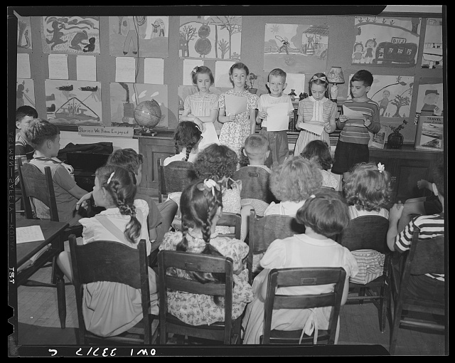 A group of four elementary school students presenting in front of their classmates