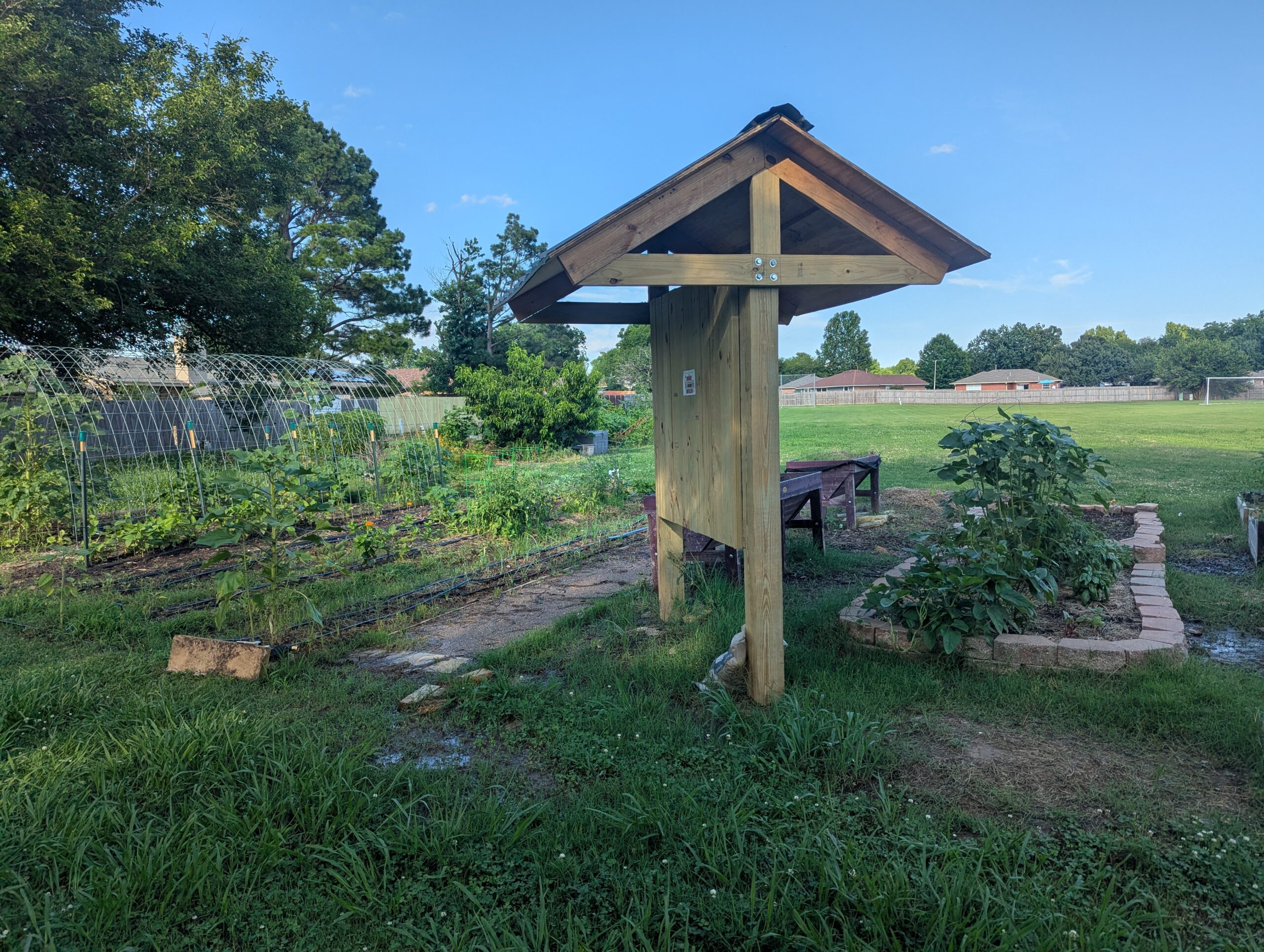 Wide view of a green garden with a wooden post in the middle of the frame