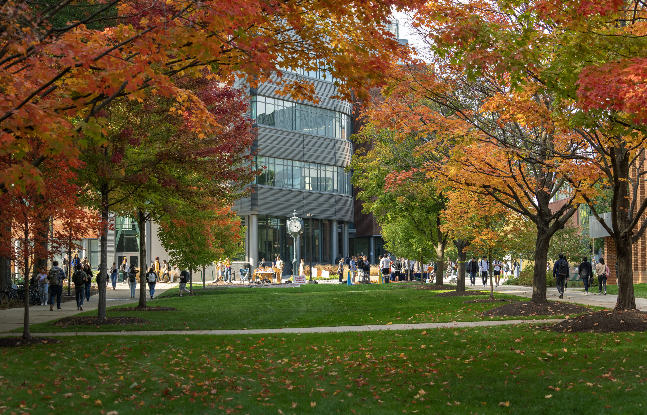 Horizon Hall and the clock on the Fairfax Campus framed by autumn leaves.
