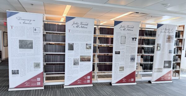 An exhibit of four posters in front of a library