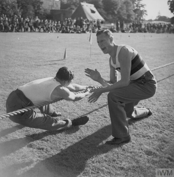 An Army tug of war team is driven on by their instructor at the 21st Army Group Sports Day in England