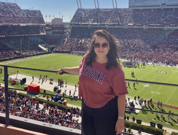 A woman standing on the stands of a the University of South Carolina football game