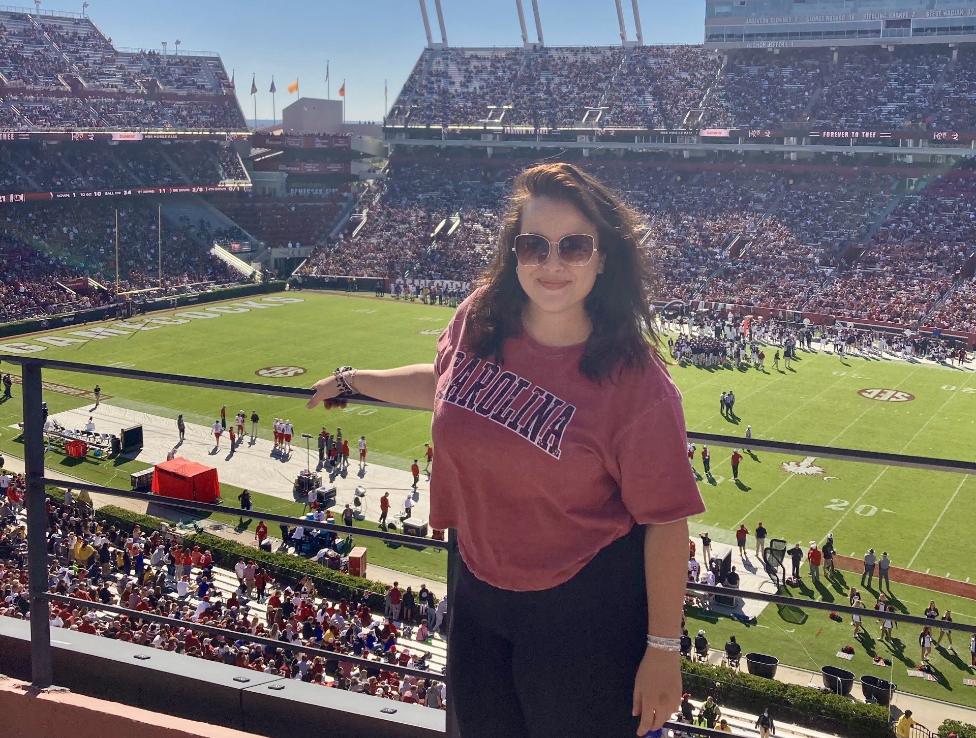 A woman standing on the stands of a the University of South Carolina football game